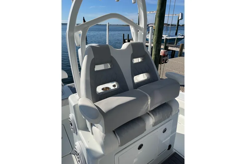 Slide: The Image of Luxury seating on 2022 Costa Custom Boats 264, docked by the water. - 15