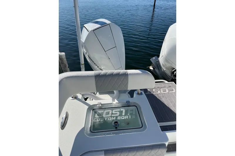 Slide: The Image of 2022 Costa Custom Boats 264 with dual engines, docked on calm water. - 16