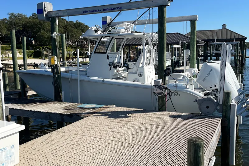 Slide: The Image of 2022 Costa Custom Boats 264 docked at a marina with Mercury outboard engine. - 2