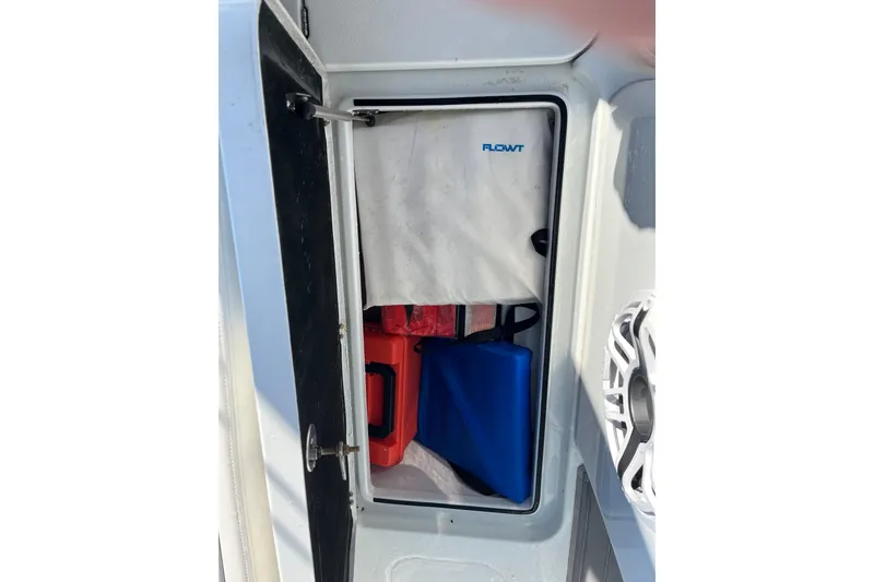Slide: The Image of Storage compartment on 2022 Costa Custom Boats 264, featuring safety equipment and accessories. - 25