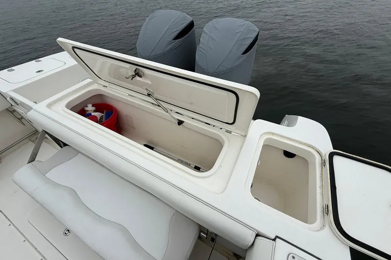 Slide: The Image of 2013 Edgewater 318CC boat with open storage compartments and covered engines. - 12