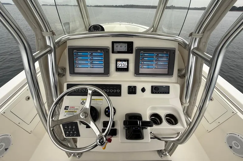 Slide: The Image of 2013 Edgewater 318CC boat dashboard with dual screens and steering wheel. - 19