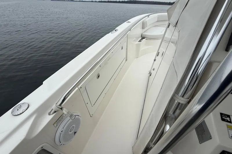 Slide: The Image of 2013 Edgewater 318CC boat interior with seating and storage, on calm water. - 23