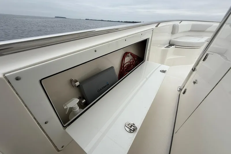 Slide: The Image of 2013 Edgewater 318CC boat interior with storage compartment and Garmin device. - 24