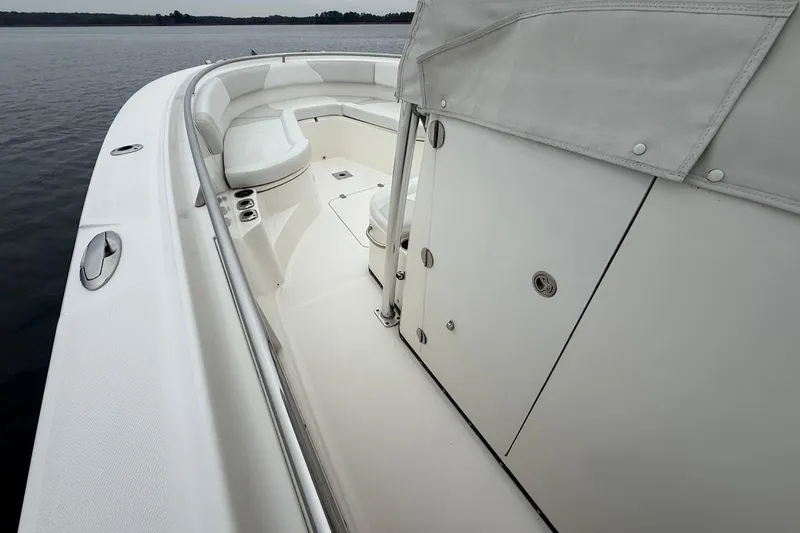 Slide: The Image of 2013 Edgewater 318CC boat interior with white seating and storage compartments. - 25
