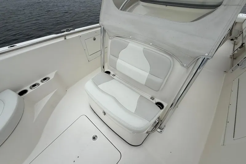 Slide: The Image of 2013 Edgewater 318CC boat interior with white seating and cup holders. - 28