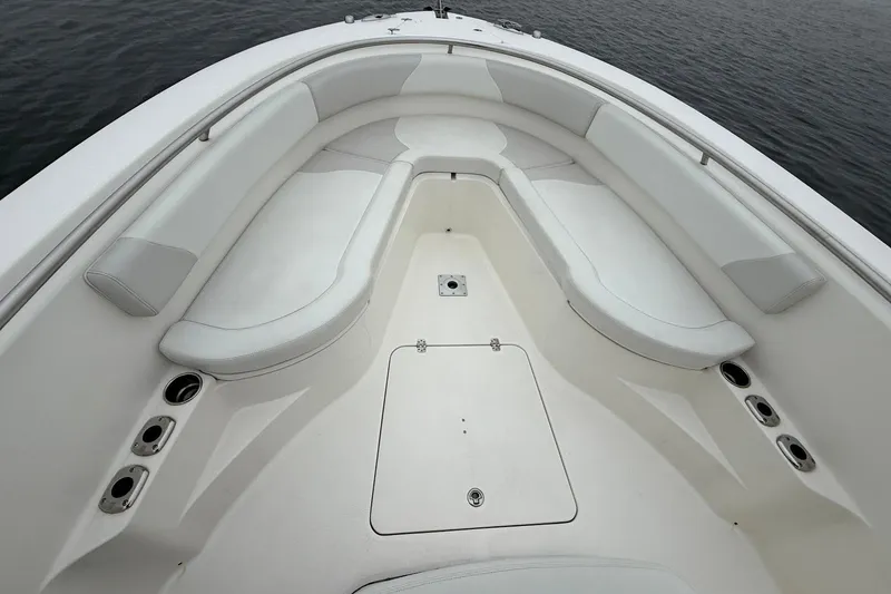 Slide: The Image of 2013 Edgewater 318CC boat interior with white cushioned seating and cup holders. - 30
