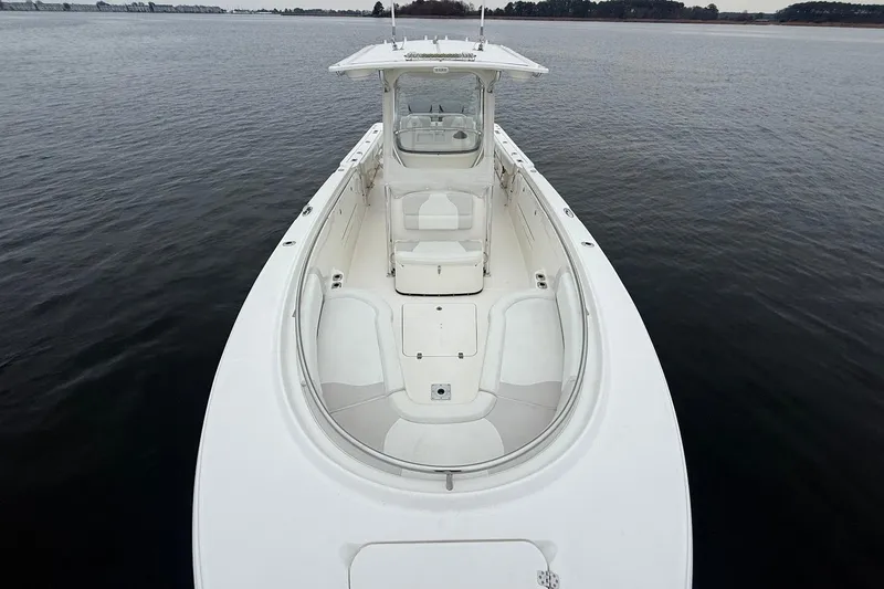 Slide: The Image of 2013 Edgewater 318CC boat on calm water, showcasing spacious deck and seating. - 33