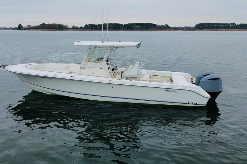 The Image of 2013 Edgewater 318CC boat on calm water, side view. - 4