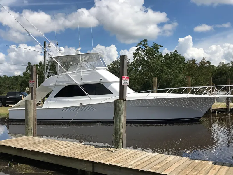 The Image of 2000 Viking 50 Convertible yacht docked on a sunny day with blue skies. - 1