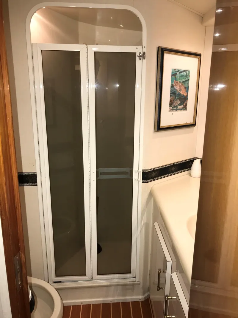 Slide: The Image of Bathroom in 2000 Viking 50 Convertible yacht with shower and framed artwork. - 17