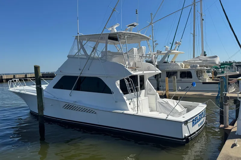 Slide: The Image of 2000 Viking 50 Convertible yacht docked at marina under clear blue sky. - 21