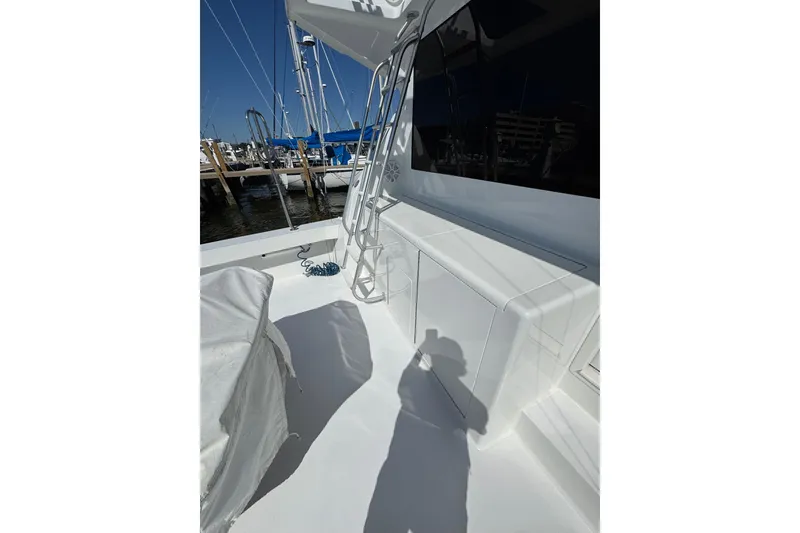 Slide: The Image of 2000 Viking 50 Convertible yacht deck with ladder and marina view. - 23