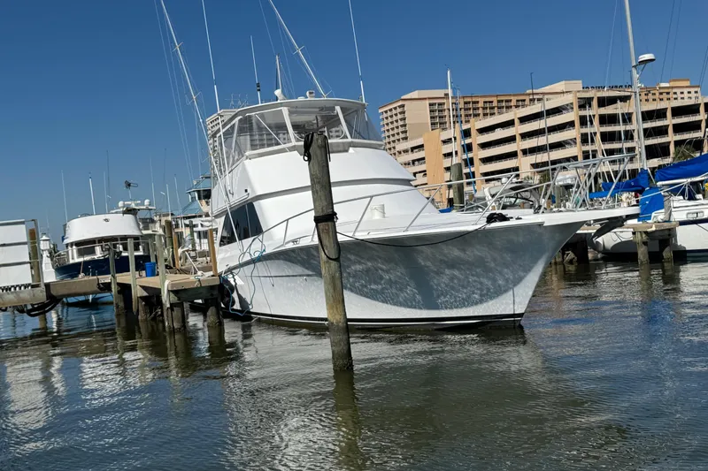 Slide: The Image of A 2000 Viking 50 Convertible yacht docked at a marina under clear blue skies. - 24