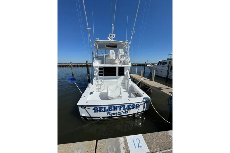 Slide: The Image of Viking 50 Convertible 2000 yacht "Relentless" docked at marina under clear blue sky. - 30