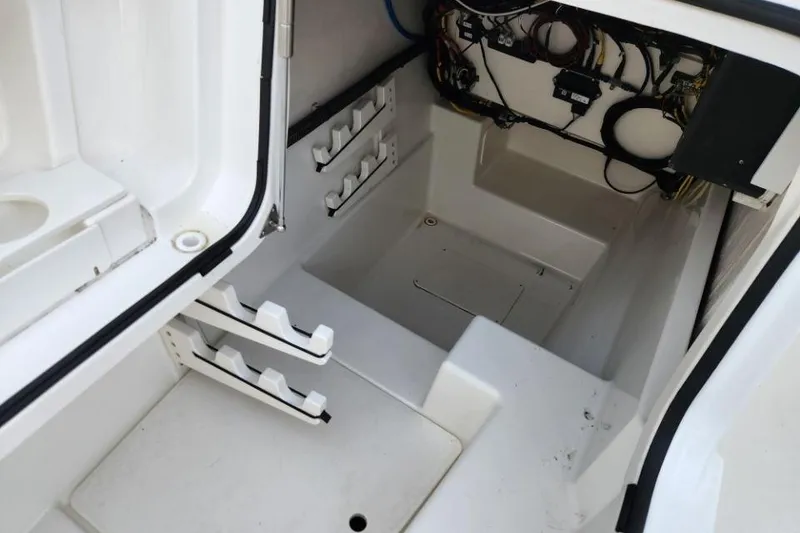 Slide: The Image of 2024 World Cat 260 DC-X boat storage compartment with rod holders and wiring. - 13