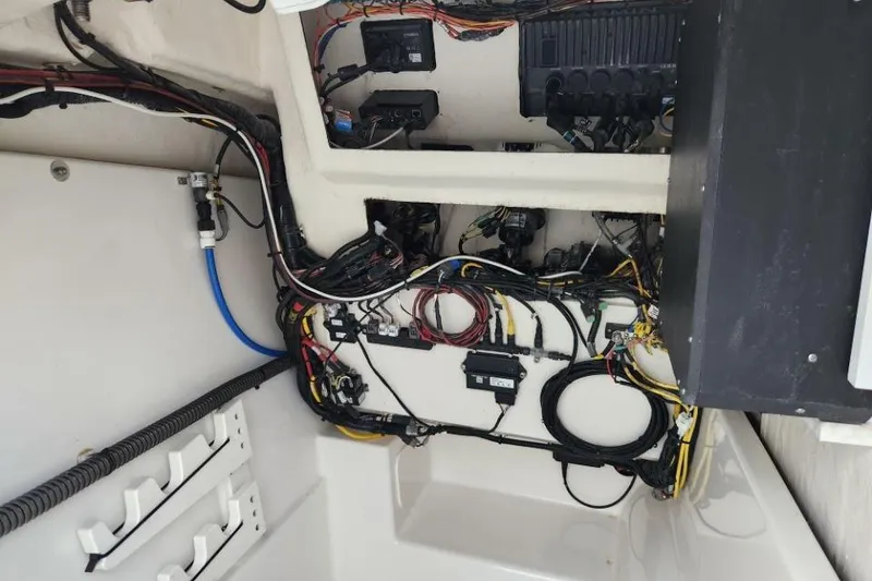 Slide: The Image of 2024 World Cat 260 DC-X boat wiring and electrical components in the interior compartment. - 14