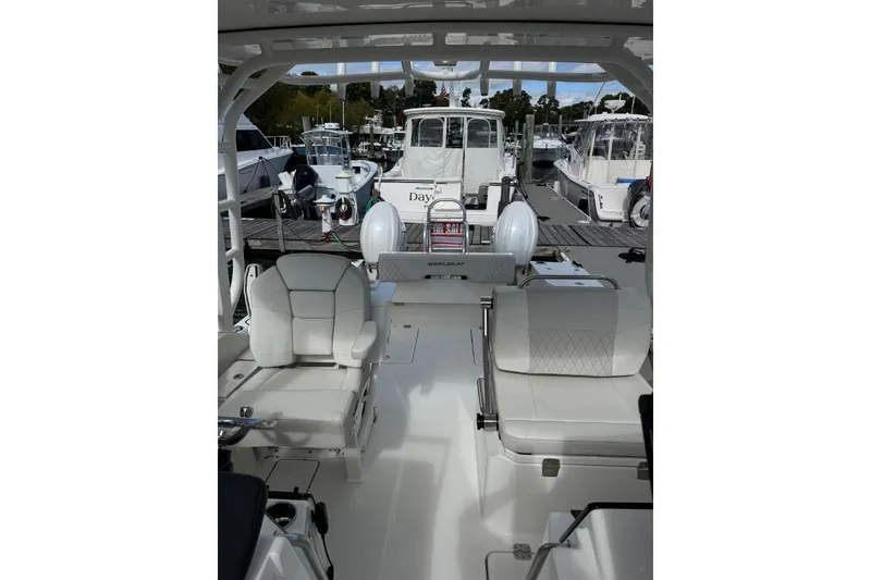 Slide: The Image of 2024 World Cat 260 DC-X boat interior at marina, featuring white seating and helm. - 17