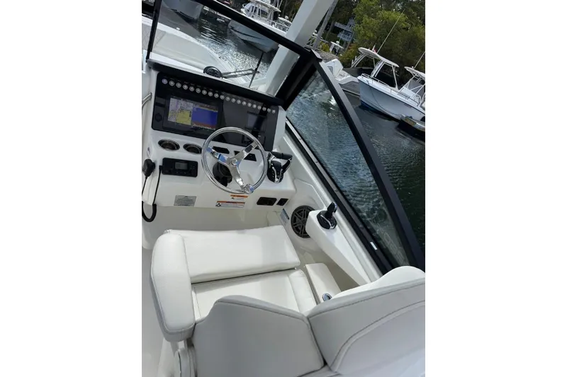 Slide: The Image of 2024 World Cat 260 DC-X boat cockpit with steering wheel and navigation display. - 21