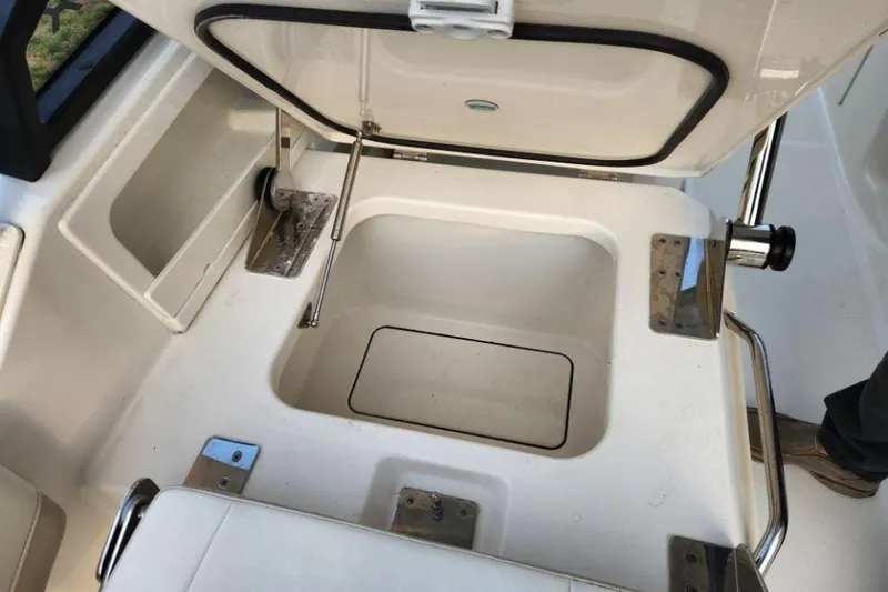 Slide: The Image of 2024 World Cat 260 DC-X boat storage compartment with open lid and stainless steel fittings. - 25