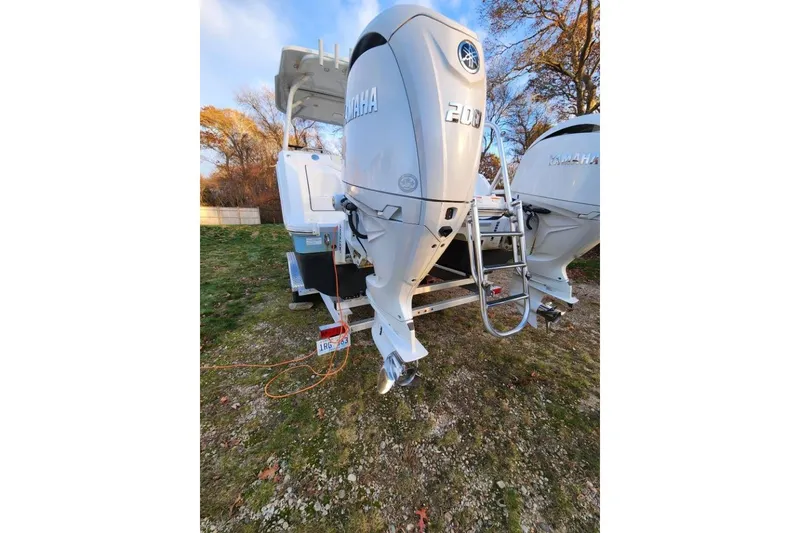 Slide: The Image of 2024 World Cat 260 DC-X boat with dual Yamaha 200 engines, parked on grass. - 39