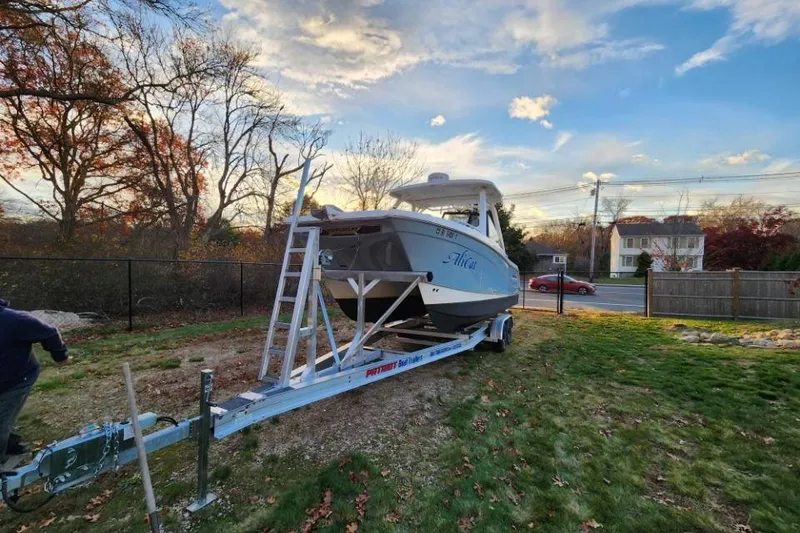 Slide: The Image of 2024 World Cat 260 DC-X boat on trailer in a suburban yard setting. - 6