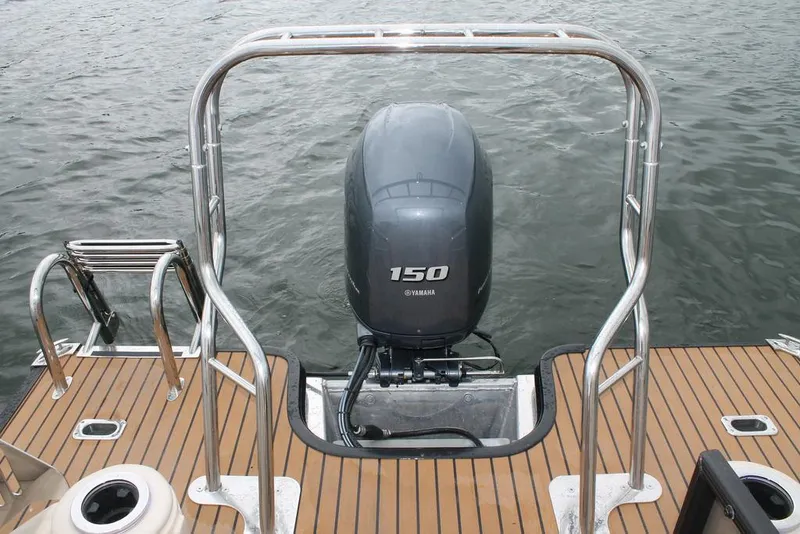 Slide: The Image of 2016 Starcraft MX 25 DL boat interior with wooden deck and cushioned seating. - 7