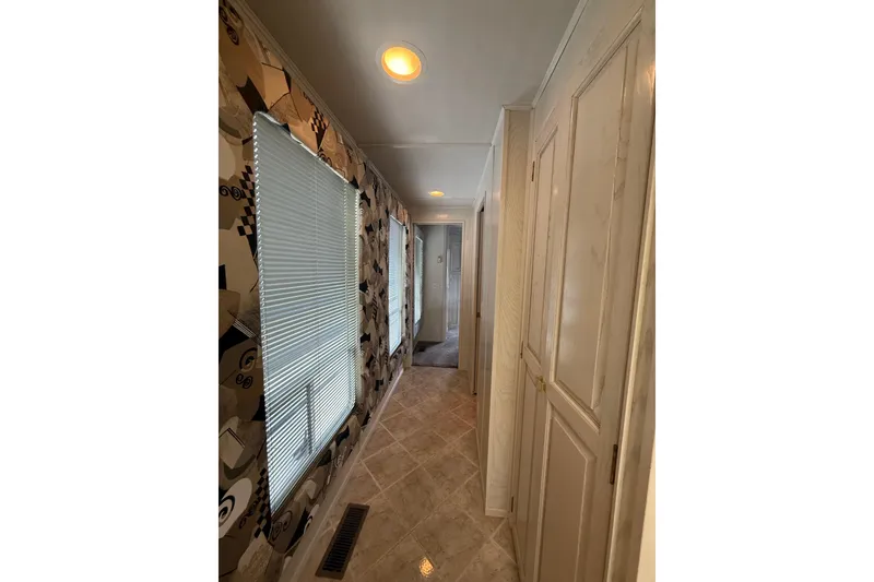 Slide: The Image of Narrow hallway inside 2000 Stardust Cruisers houseboat with patterned walls and tiled floor. - 13