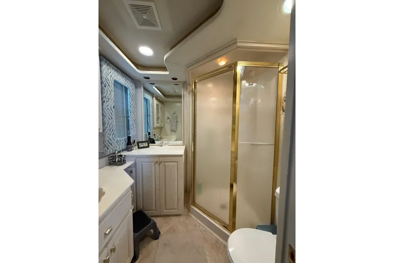 Slide: The Image of Luxurious bathroom in 2000 Stardust Cruisers houseboat with gold-trimmed shower. - 15