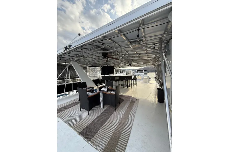 Slide: The Image of Spacious 2000 Stardust Cruisers houseboat deck with seating and dining area. - 16