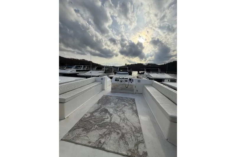 Slide: The Image of Stardust Cruisers 2000 houseboat deck with seating, under a dramatic cloudy sky. - 19