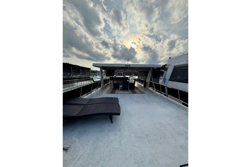 Slide: The Image of 2000 Stardust Cruisers houseboat deck with lounge chairs under dramatic cloudy sky. - 21