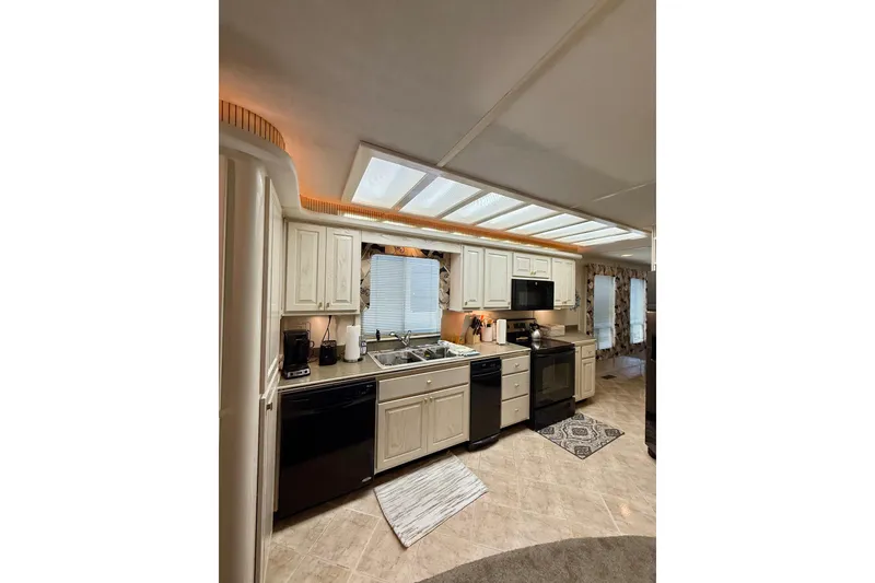 Slide: The Image of Modern kitchen interior on a 2000 Stardust Cruisers houseboat, featuring appliances and ample lighting. - 7