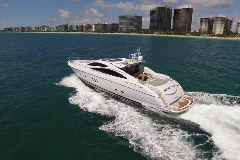 Slide: The Image of 2006 Sunseeker Predator 82 yacht cruising near a coastal city skyline. - 4