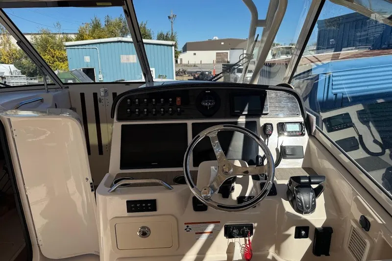 Slide: The Image of 2022 Grady-White Freedom 335 boat cockpit with steering wheel and control panel. - 11