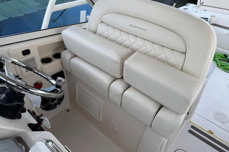 Slide: The Image of 2022 Grady-White Freedom 335 boat interior with luxurious seating and steering wheel. - 15