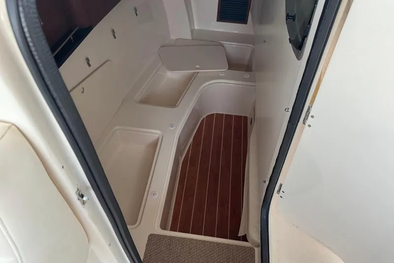Slide: The Image of 2022 Grady-White Freedom 335 interior with storage compartments and wood flooring. - 16