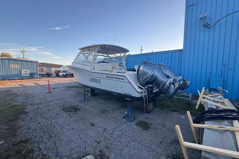 Slide: The Image of 2022 Grady-White Freedom 335 boat on stands near blue building. - 2