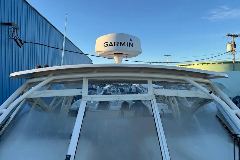 Slide: The Image of 2022 Grady-White Freedom 335 boat with Garmin radar, docked near blue building. - 21