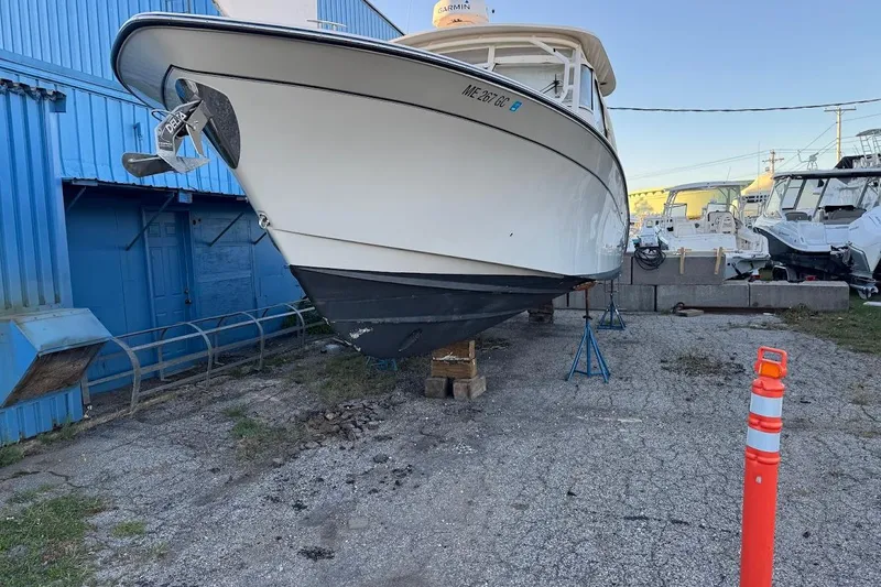 Slide: The Image of 2022 Grady-White Freedom 335 boat on stands near blue building. - 25