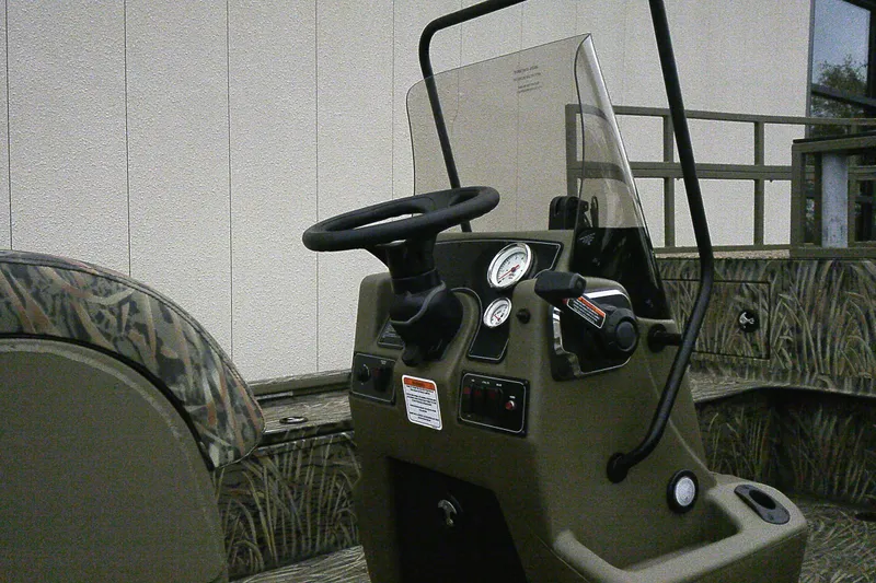 Slide: The Image of 2026 Tracker Grizzly 2072 CC Sportsman Kicker boat console with camo seating and controls. - 4