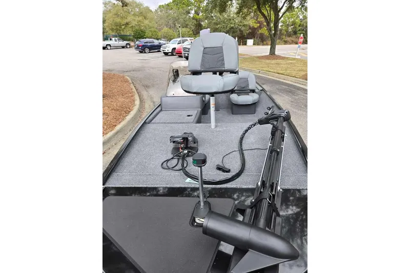 Slide: The Image of 2026 Tracker Bass Tracker Classic XL boat with seating and equipment in a parking lot. - 2