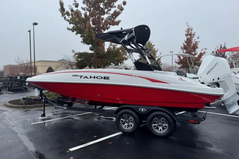 The Image of 2025 Tahoe 2150 boat on trailer in parking lot, overcast day. - 0