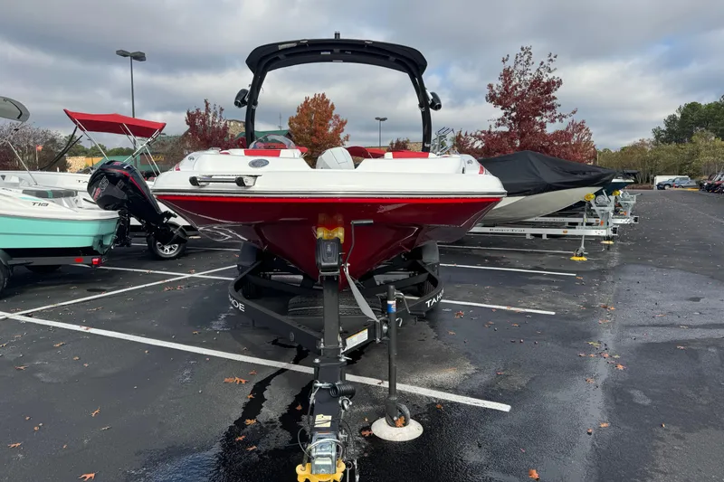 Slide: The Image of 2025 Tahoe 2150 boat in parking lot, red hull, overcast sky. - 2