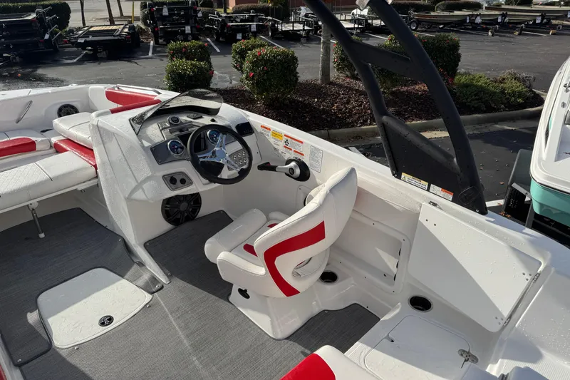 Slide: The Image of 2025 Tahoe 2150 boat interior with red and white seating, steering wheel, and dashboard. - 4