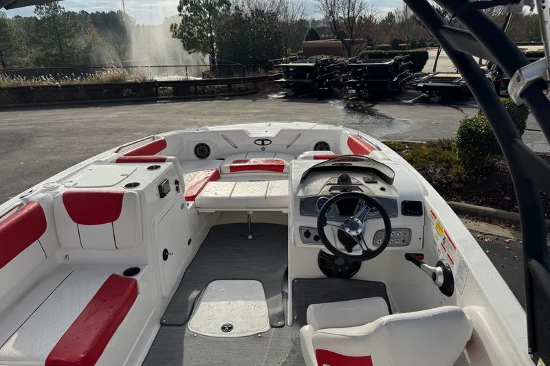 Slide: The Image of 2025 Tahoe 2150 boat interior with red and white seating, steering wheel, and dashboard. - 6