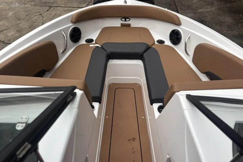 Slide: The Image of 2026 Tahoe 210 S boat interior with brown and black seating, cup holders, and speakers. - 115
