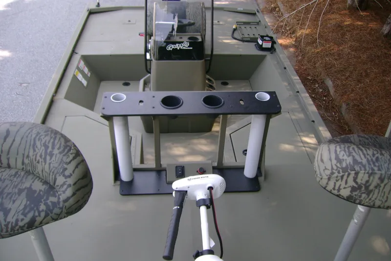 Slide: The Image of 2026 Tracker Grizzly 2072 CC Sportsman boat interior with camo seats and fishing rod holders. - 6