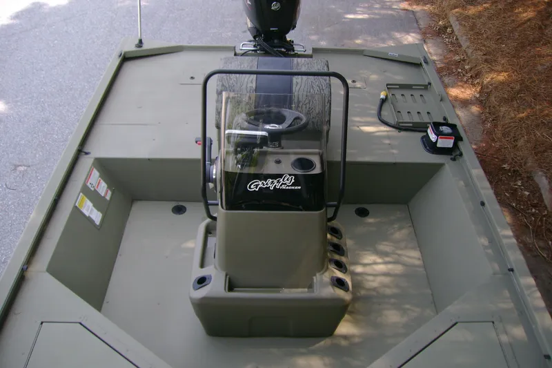 Slide: The Image of 2026 Tracker Grizzly 2072 CC Sportsman boat interior with steering console and seating area. - 7