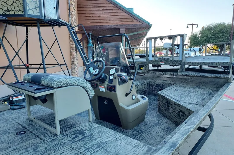 Slide: The Image of 2026 Tracker Grizzly 2072 CC Sportsman boat with camouflage interior and control console. - 2